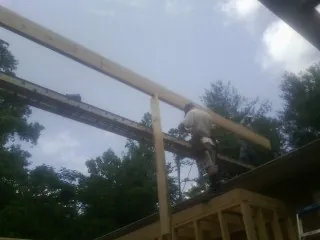 Carpenter setting a ridge beam over a new addition frame — Ice Dam Removal by Roofing Brothers in Wahpeton