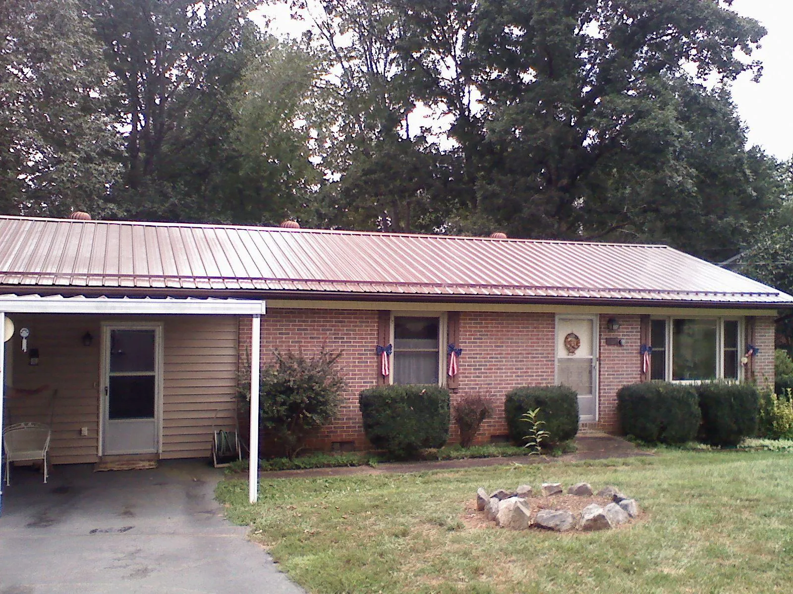 Bronze metal roof and carport on a brick ranch home — Roof Repair work by our crew in Wahpeton